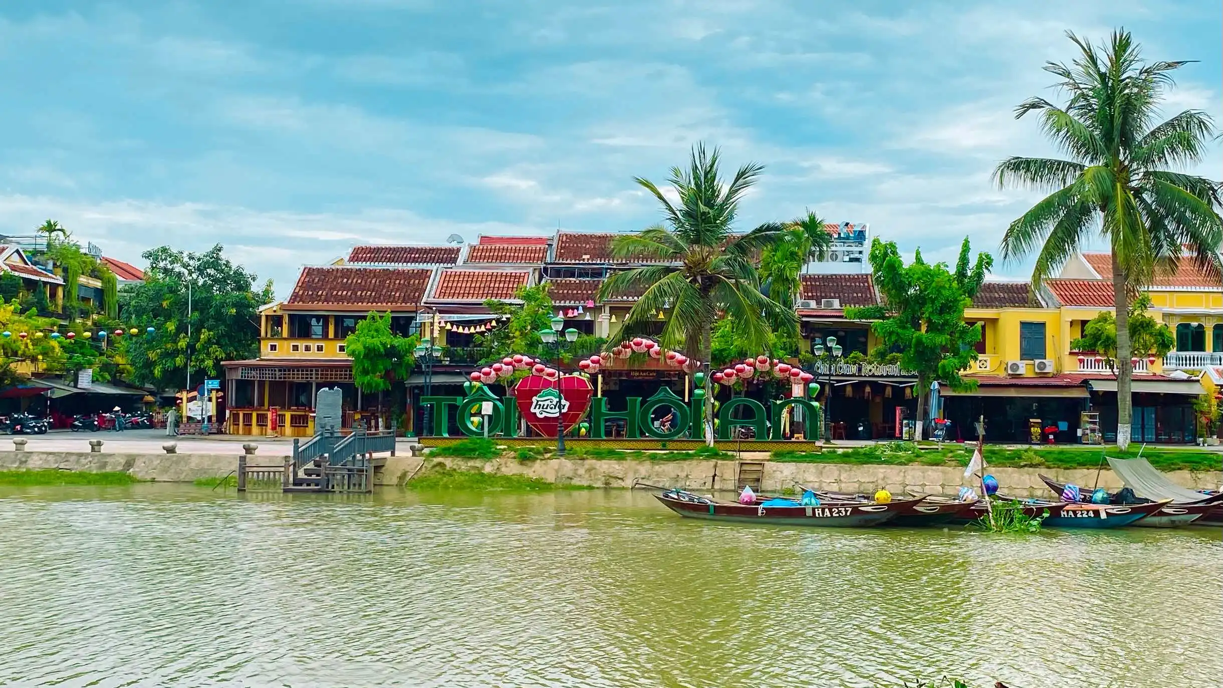 Old building and a river with green trees in Hoi An