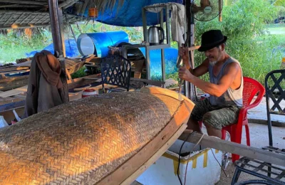 An old man crafting wooden boat in Hoi An