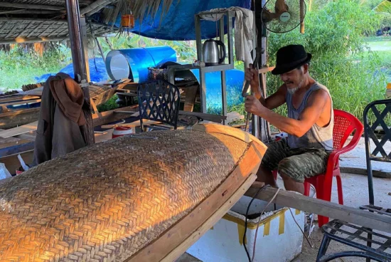 An old man crafting wooden boat in Hoi An